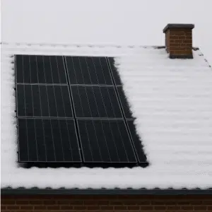 Solar panels installed on a residential roof partially covered in snow, with clear panels exposed and a brick chimney visible nearby.